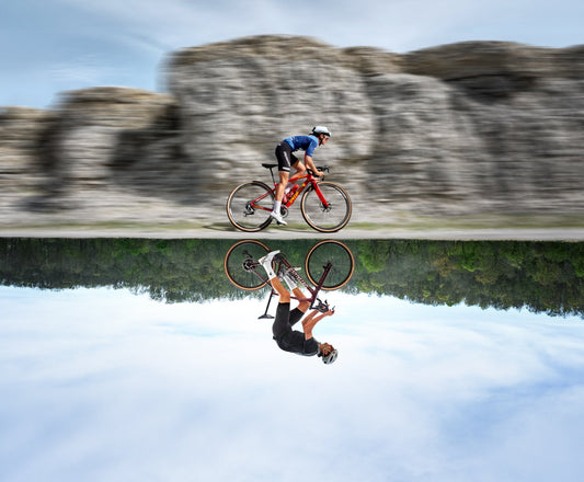 A Specialized Diverge 4 being ridden next to a body of water, with a mirror image reflected.